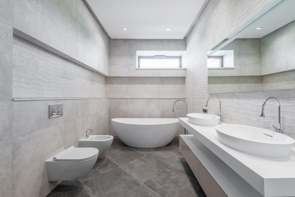 bathroom with a bath and grey marble wall and floor tiles